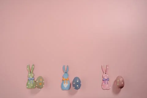 Easter Bunny and Painted Eggs on Pink Background with Copy Space Stock Photos