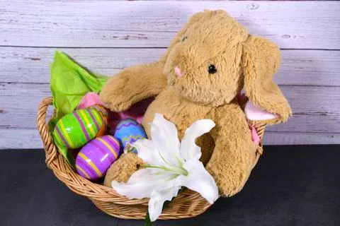 Easter Bunny in basket with Easter eggs Stock Photos