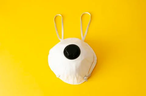 Easter bunny concept. Protective face mask on yellow background. Copy space.  Stock Photos