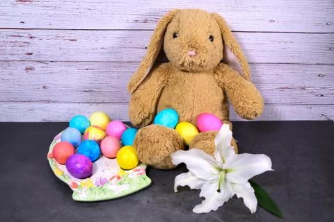 Easter Bunny with Easter eggs and lily on wood and slate Stock Photos