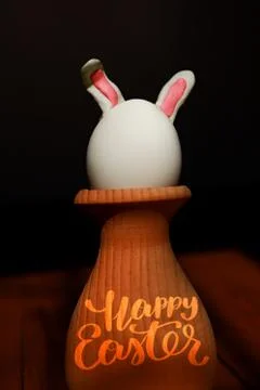 Easter bunny egg on dark background with happy easter calligraphy greeting Stock Photos