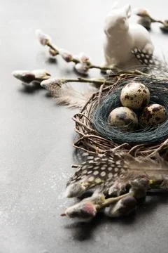 Easter bunny with eggs in nest, spring willow on grey. Space for text. East.. Stock Photos