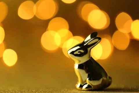 Easter bunny. Golden easter metallic bunny on golden glitter background . Stock Photos