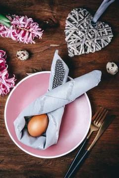 Easter bunny from a napkin and a Easter egg on a pink plate and a wooden ba.. Stock Photos