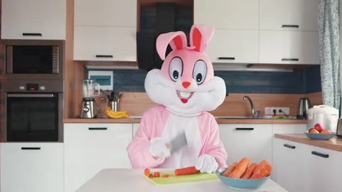 Easter Bunny or rabbit cutting carrot, cooking, preparing for celebrate Happy Vidéo 145690300