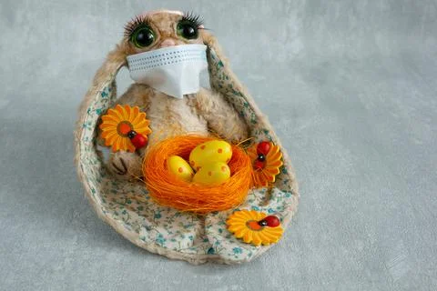 Easter bunny in protective mask with colored eggs Foto stock