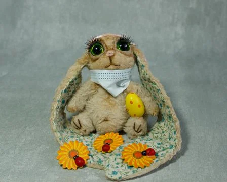 Easter bunny in protective mask with colored eggs Stock Photos