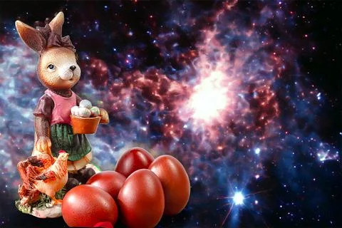Easter Bunny sits among colorful eggs on a colored background. Stock Photos