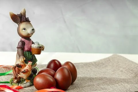 Easter Bunny sits among multi-colored eggs on a light background. Easter ba.. 库存照片