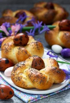 Easter buns, colored eggs and flowers on a gray concrete background. Foto stock