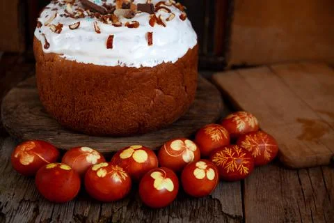 Easter cake and colored eggs. Rustic food on a wooden table. Egg colored with Stock-Fotos