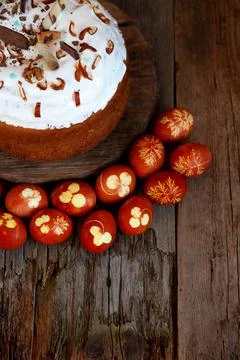 Easter cake and colored eggs. Rustic food on a wooden table. Egg colored with Stock Photos