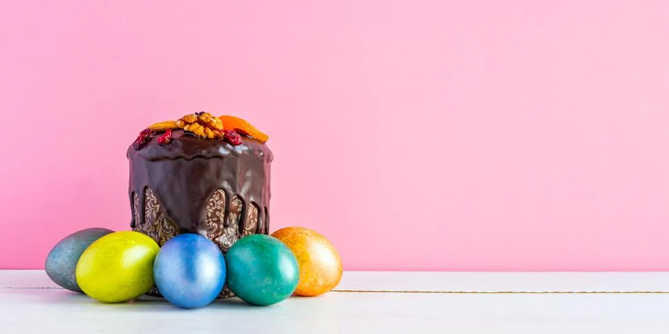Easter cake and colored eggs on pink background. Holiday food and easter co.. Stock Photos