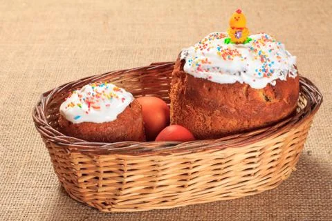 Easter cake and colorful Easter eggs in wicker basket. Stock Photos