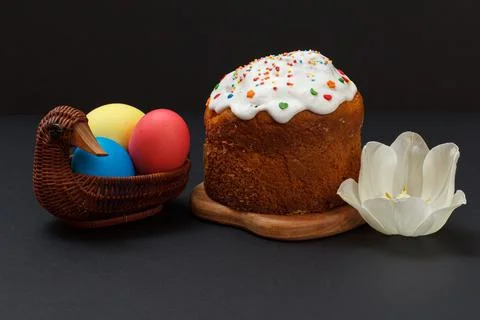Easter cake and colorful Easter eggs in wicker basket. Stock Photos