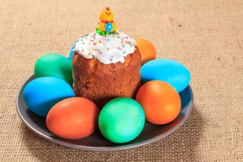 Easter cake and painted eggs on a plate with sackcloth on the background. Stock Photos