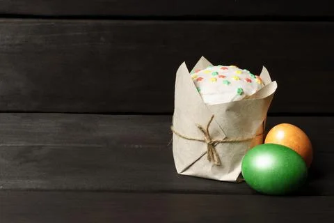 Easter cake and two colored Easter eggs on a dark wooden background. banner Foto stock