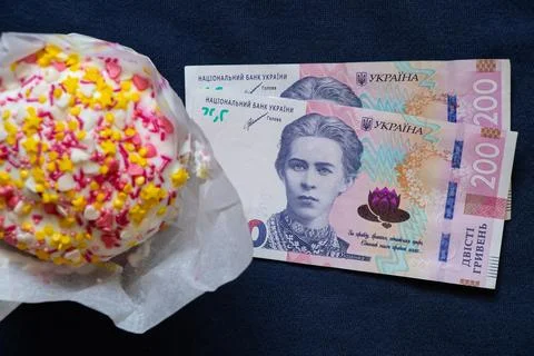 Easter cake and two hundred hryvnia bills on a blue background, Easter expe.. Stock Photos