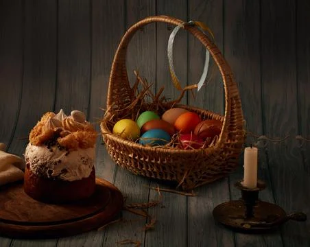 Easter cake, a basket with colored eggs, a bronze candlestick with an extingu Stock Photos