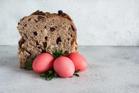 Easter cake with chocolate drops, pink-colored eggs on gray background. Stock Photos