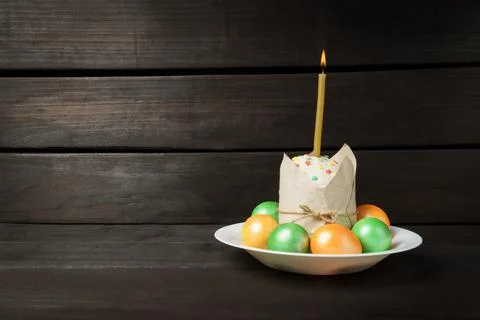 Easter cake with colored painted eggs on a dark background. a church candle i Stock Photos