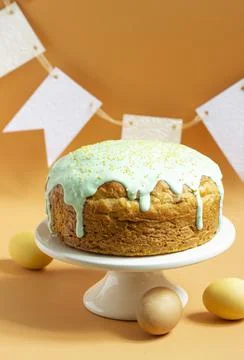 Easter cake covered with icing on a cake bowl and Easter eggs. Festive concept. Stock Photos