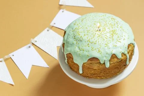Easter cake covered with icing on a cake bowl and Easter eggs. Festive concept. Stock Photos