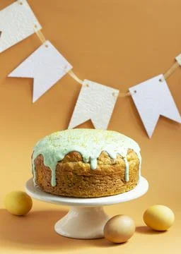 Easter cake covered with icing on a cake bowl and Easter eggs. Festive concept. Stock Photos