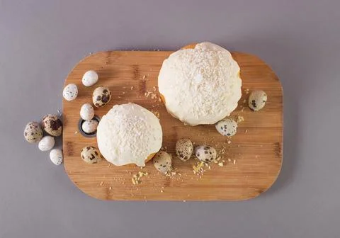 Easter cake covered with white glaze quail eggs on a wooden cutting board top Stock Photos