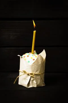 Easter cake on a dark background, with a burning church candle, Stock Photos