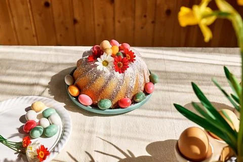 Easter cake decorated with icing sugar, small colorful chocolate eggs and d.. Stock Photos
