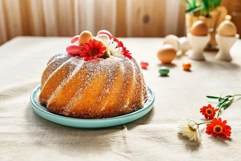 Easter cake decorated with icing sugar, small colorful chocolate eggs and d.. Stock Photos