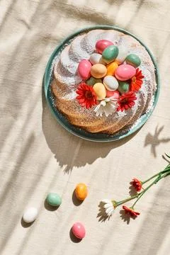 Easter cake decorated with icing sugar, small colorful chocolate eggs and d.. Stock Photos