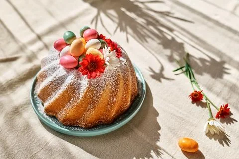 Easter cake decorated with icing sugar, small colorful chocolate eggs and d.. Stock Photos