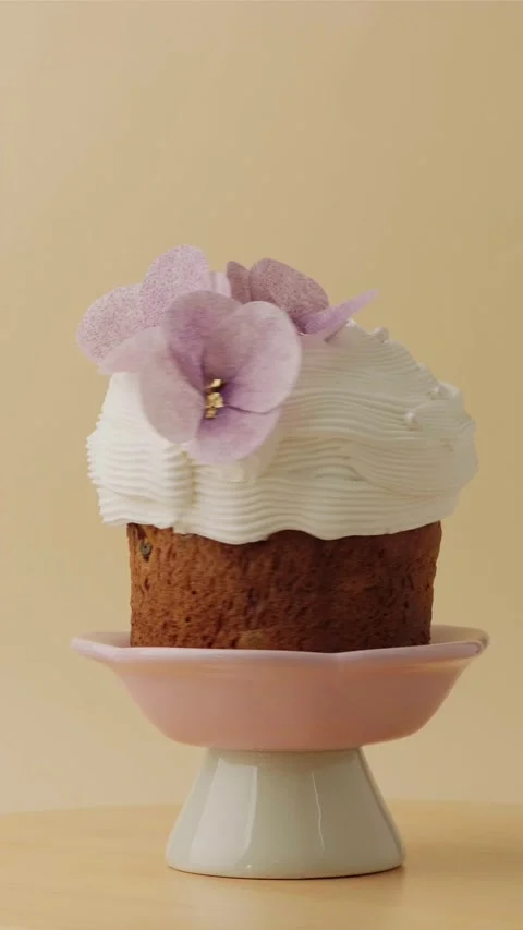 Easter cake decorated with white icing and edible violet flowers Stock Footage 306918893