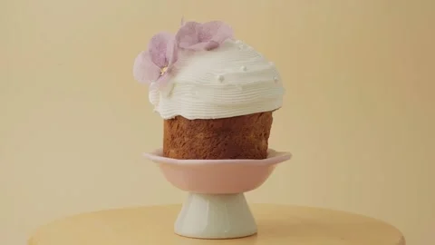 Easter cake decorated with white icing and edible violet flowers Stock Footage 306918985