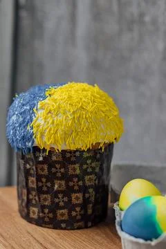 Easter cake is decorated with yellow-blue sprinkles on a gray background. p.. Stock Photos