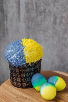 Easter cake is decorated with yellow-blue sprinkles on a gray background. p.. Stock Photos