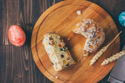 Easter cake divided on pieces over wooden board. Stock Photos