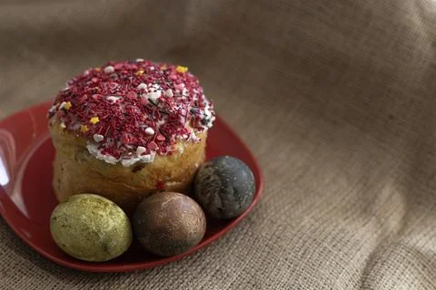 Easter cake with Easter eggs in a red plate on a table with a tablecloth 库存照片