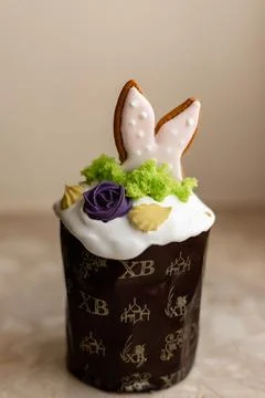 Easter cake with a lit candle. Easter colorful eggs in a basket on the table Stock Photos