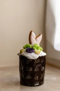 Easter cake with a lit candle. Easter colorful eggs in a basket on the table Stock Photos