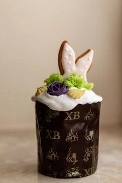 Easter cake with a lit candle. Easter colorful eggs in a basket on the table 写真素材