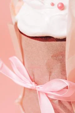 Easter cake in paper packaging and pink bow close-up Stock Photos