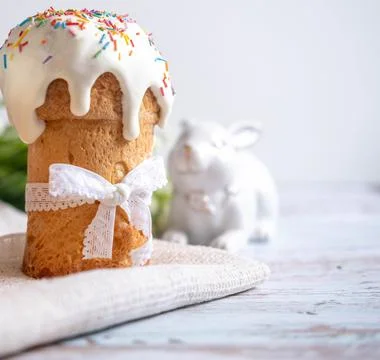 Easter cake, with a porcelain rabbit in the background, on a white table. Sel Stock Photos