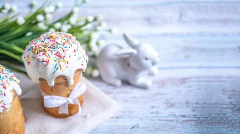 Easter cake, with a porcelain rabbit in the background, on a white table Stock Photos