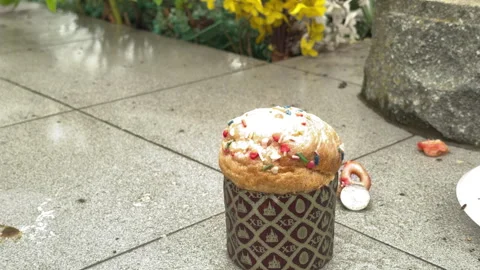 Easter Cake Sits On A Wet Tiled Path Outside A Grave Site Stock Footage 335153041