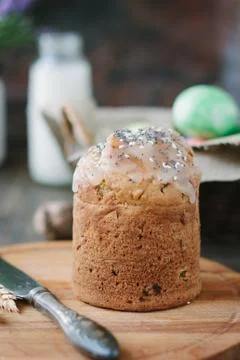 Easter cake standing on board against the basket with easter eggs. Stock Photos