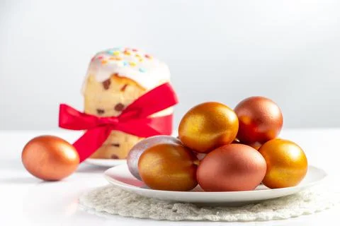 Easter cake with sweet icing and golden eggs on white plate. Stock Photos