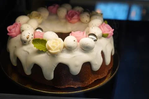 Easter cake topped with white icing and adorned with decorative eggs and ro.. 写真素材